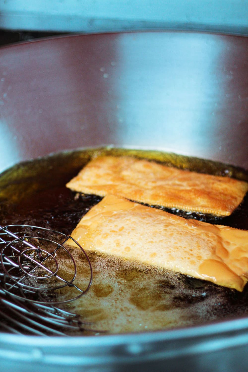 Pastéis dourados fritando no óleo quente