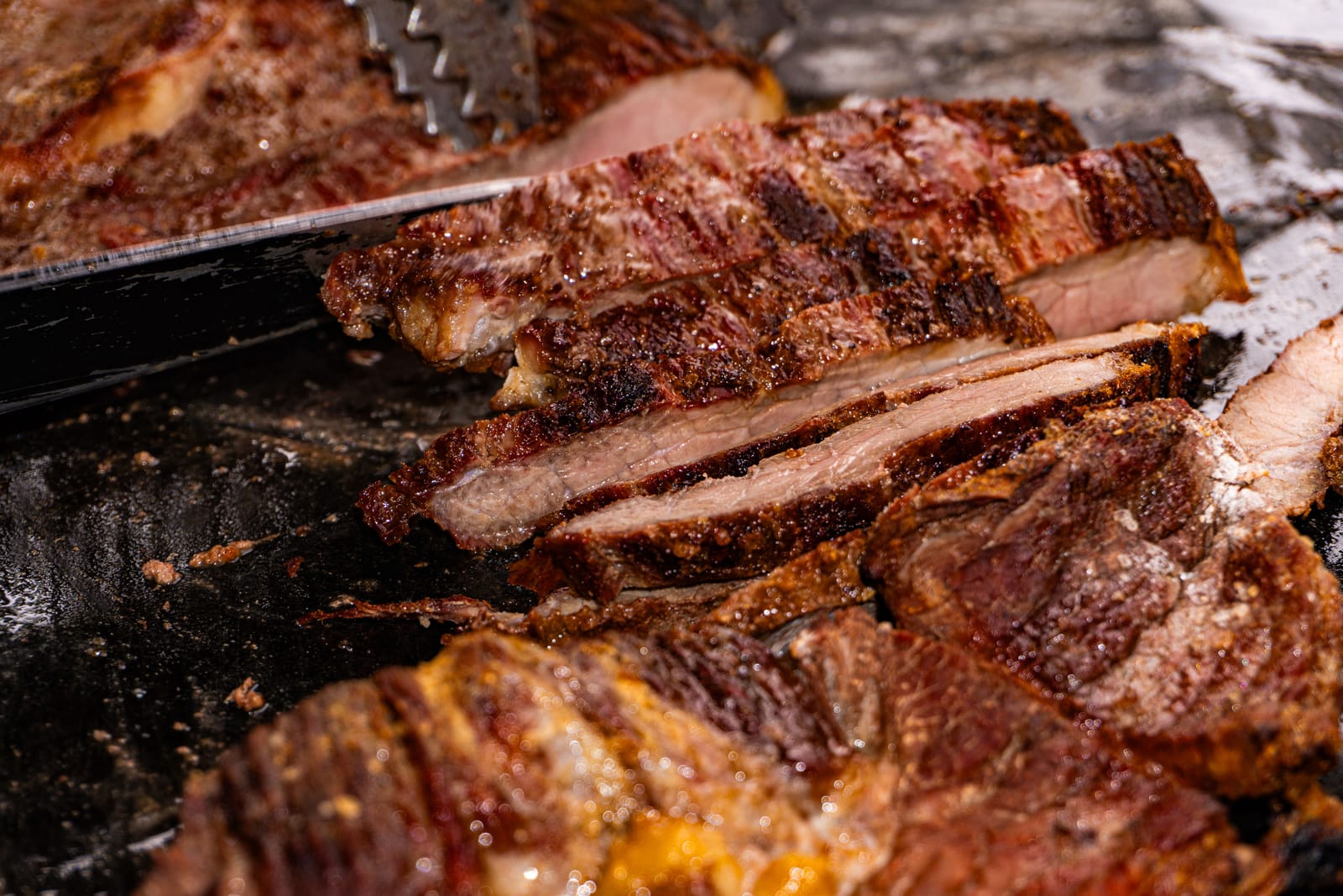Cortes de carne grelhados sendo fatiados