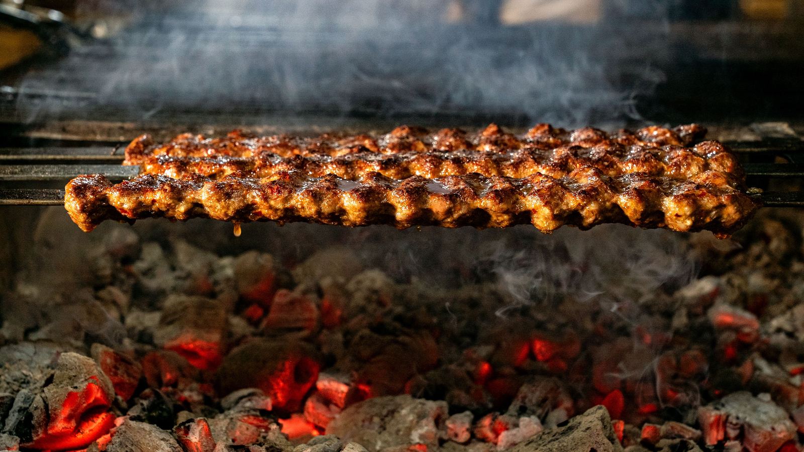 Espetos de kafta assando sobre o carvão em brasa