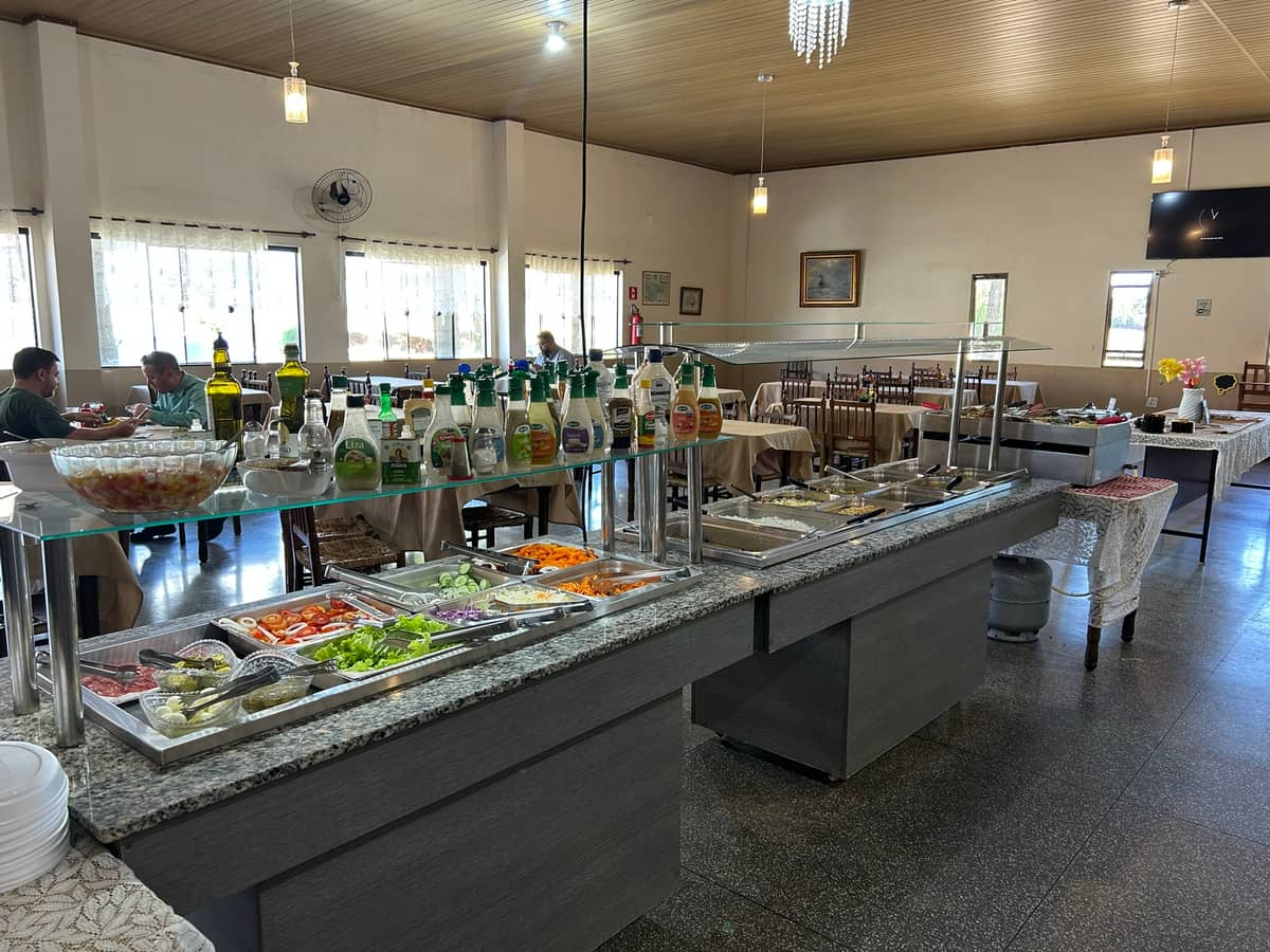 Balcão do self-service com saladas e pratos quentes no salão do restaurante
