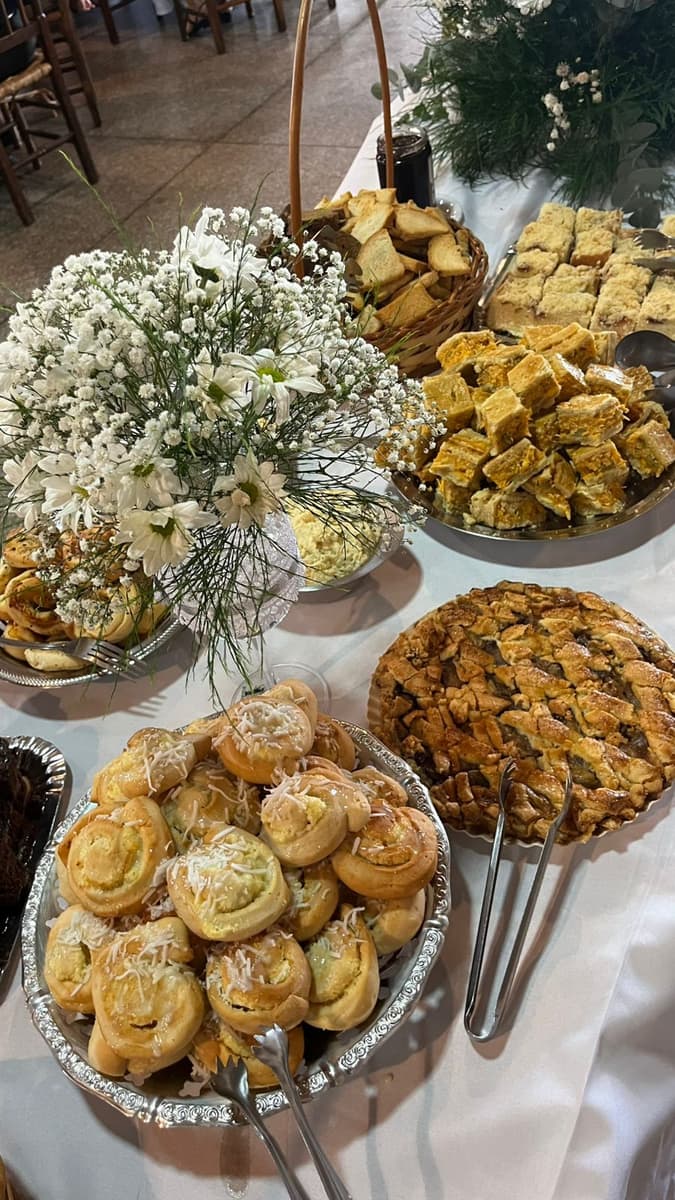 Folhados e doces com um arranjo de flores brancas