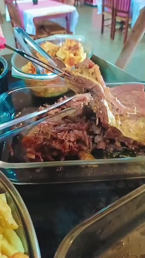 Costela assada sendo desfiada no buffet