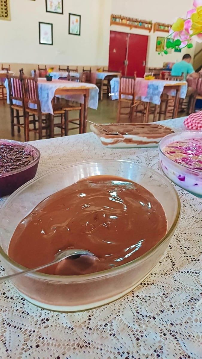 Creme de chocolate numa tigela de vidro na mesa de sobremesas, com o salão ao fundo