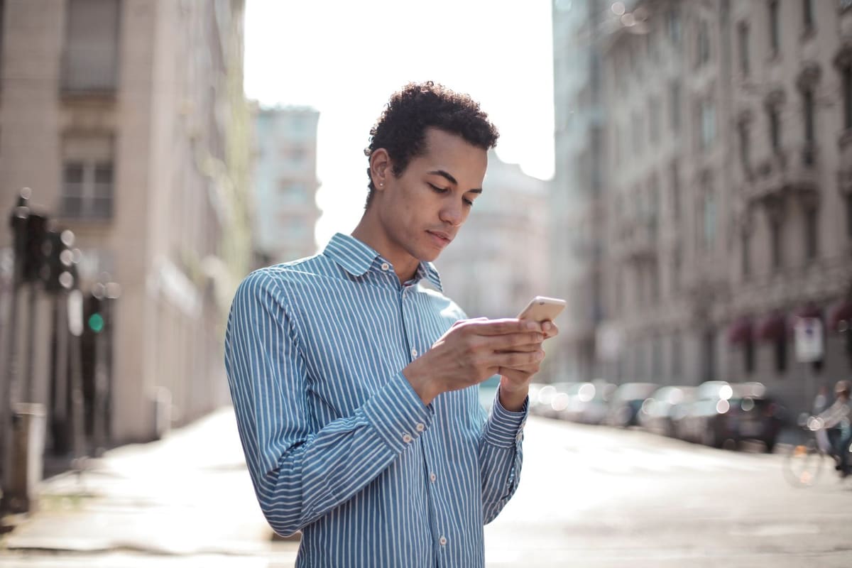 Homem na rua olhando o celular
